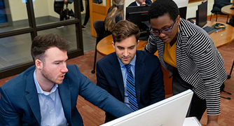 image of three students looking at a computer